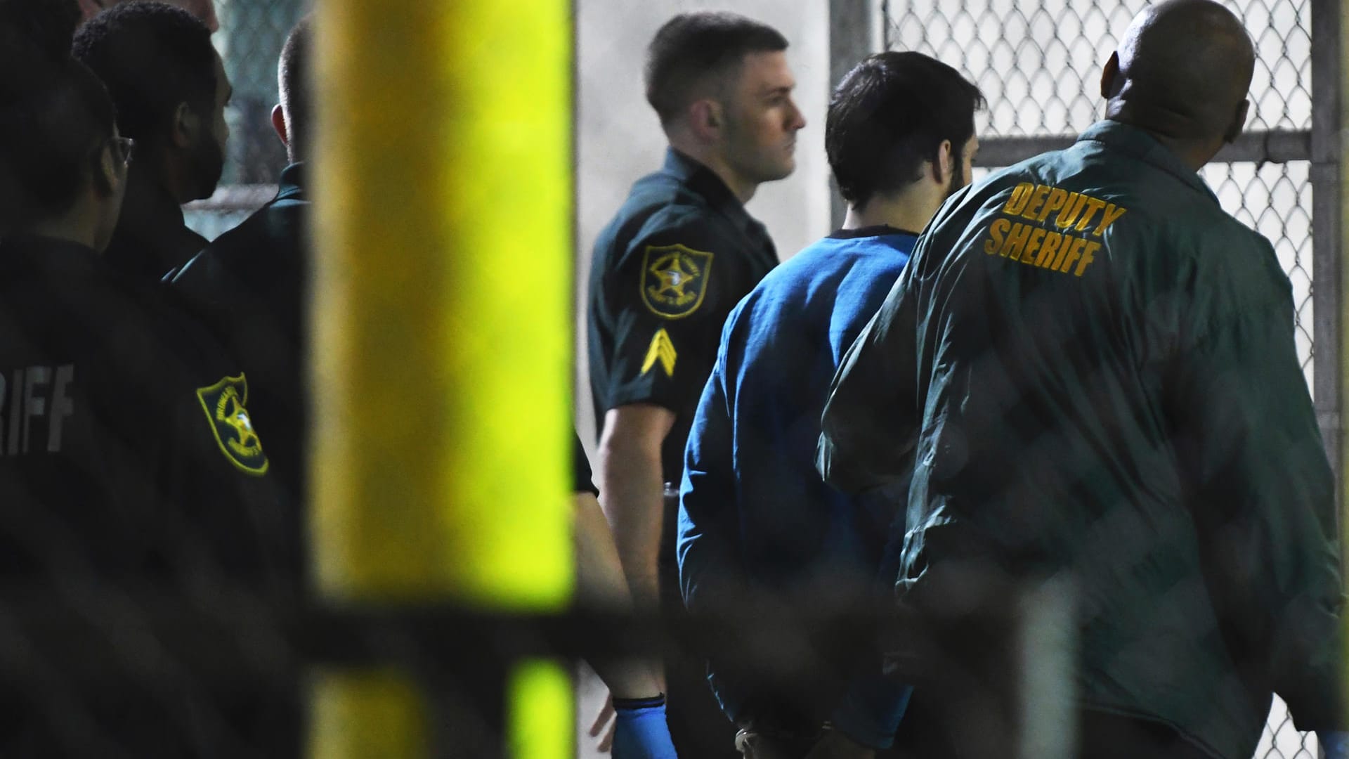 Polizisten bringen den mutmaßlichen Todesschützen Esteban Santiago ins Gefängnis von Broward County. Polizisten bringen den mutmaßlichen Todesschützen Esteban Santiago ins Gefängnis von Broward County.