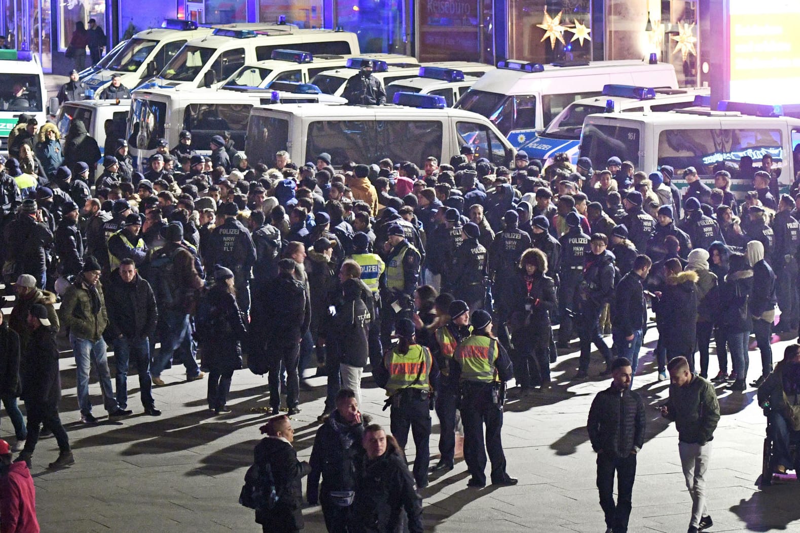 Polizisten umringen an Silvester vor dem Hauptbahnhof in Köln eine Gruppe südländisch aussehender Männer.