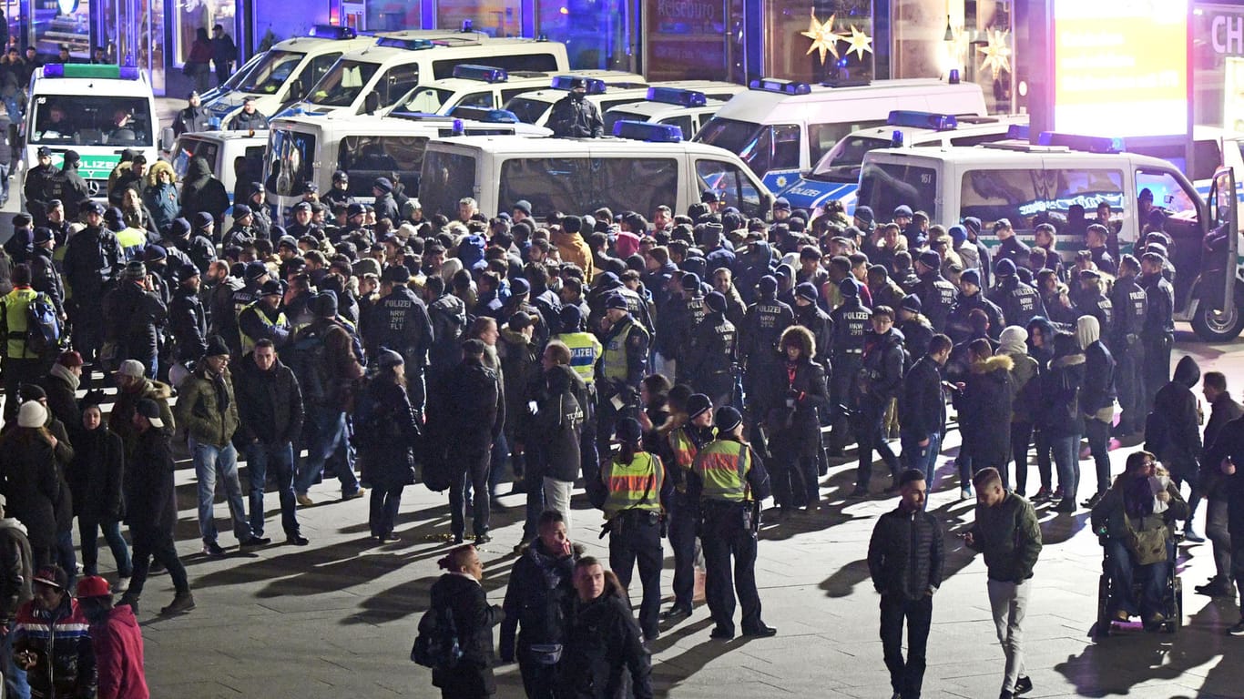 Polizisten umringen an Silvester vor dem Hauptbahnhof in Köln eine Gruppe südländisch aussehender Männer.