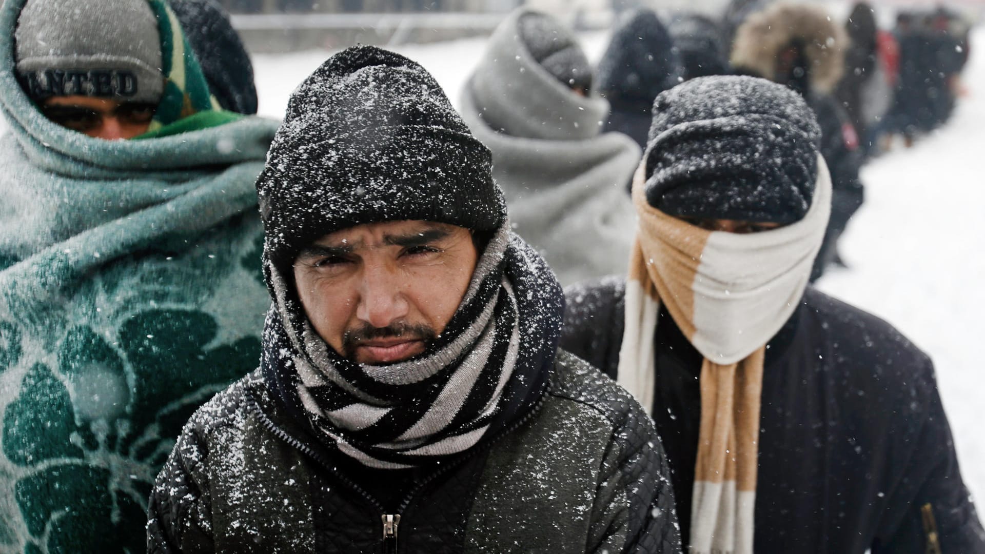 Bei eisigen Temperaturen harren Flüchtlinge unter freiem Himmel in Serbien aus. Sie warten in Decken gehüllt vor einem verlassenen Kaufhaus in Belgrad auf die Ausgabe von Essen.