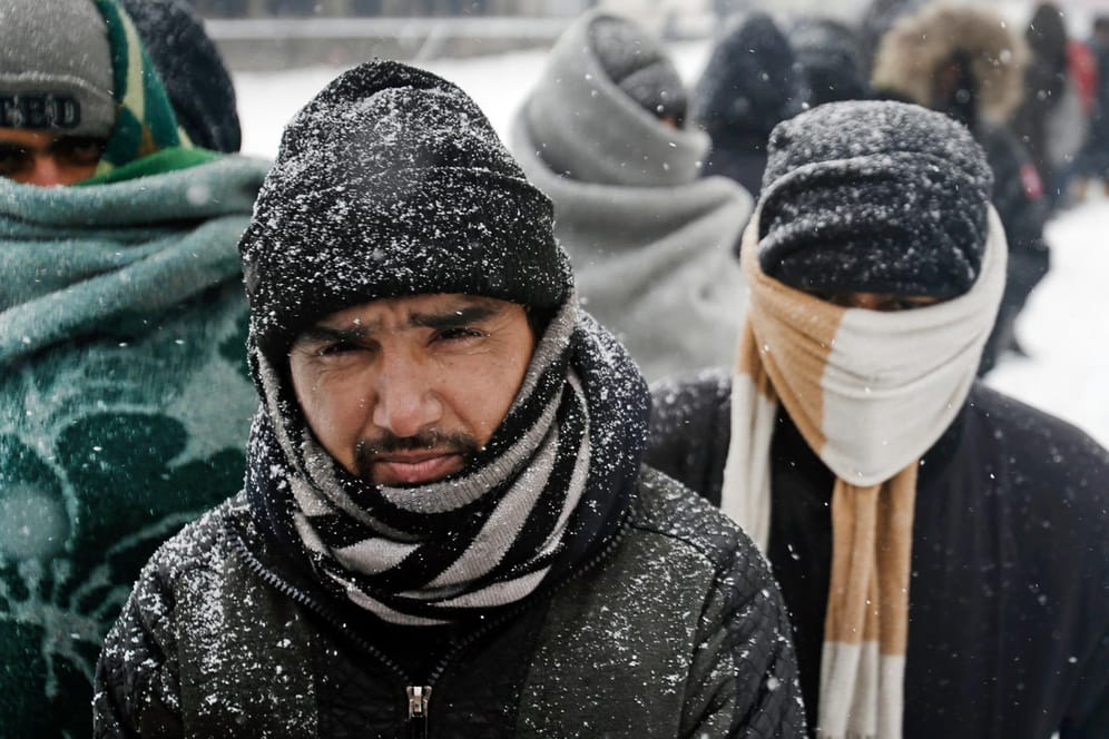 Bei eisigen Temperaturen harren Flüchtlinge unter freiem Himmel in Serbien aus. Sie warten in Decken gehüllt vor einem verlassenen Kaufhaus in Belgrad auf die Ausgabe von Essen.