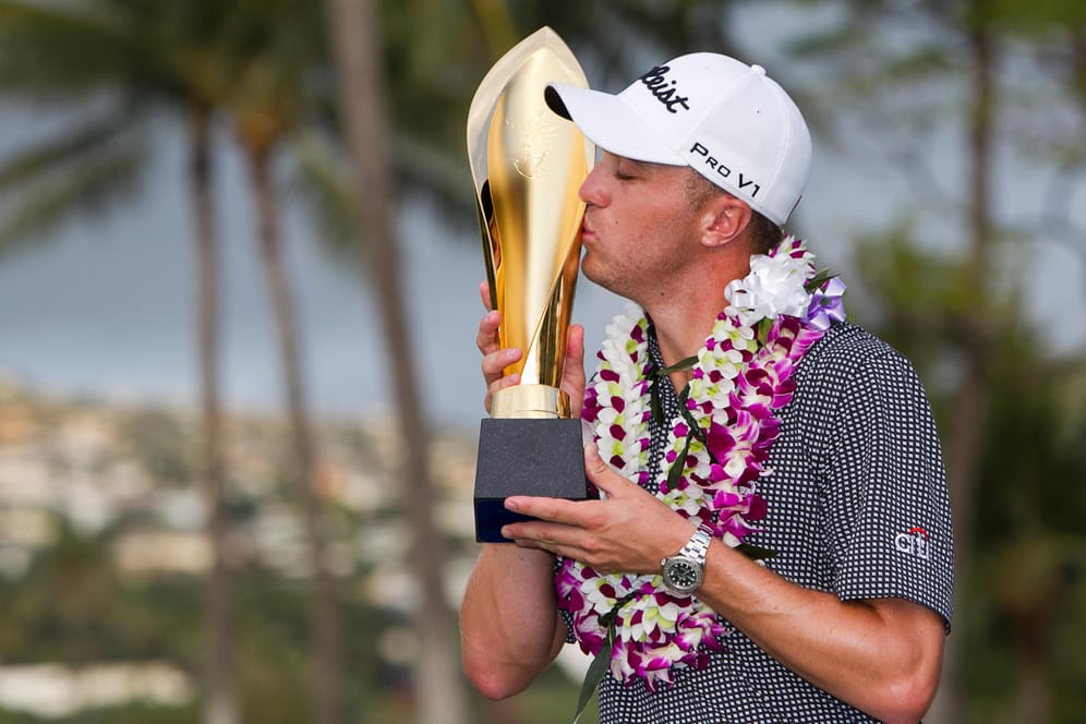 Justin Thomas küsst seine Trophäe des Golfturniers in Honolulu.