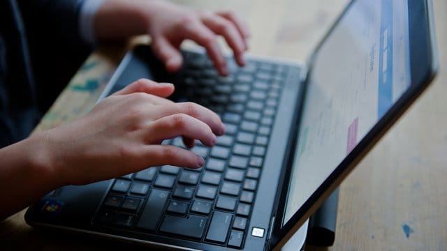 Ein junges Mädchen sitzt an einem Laptop. Ein junges Mädchen sitzt an einem Laptop.