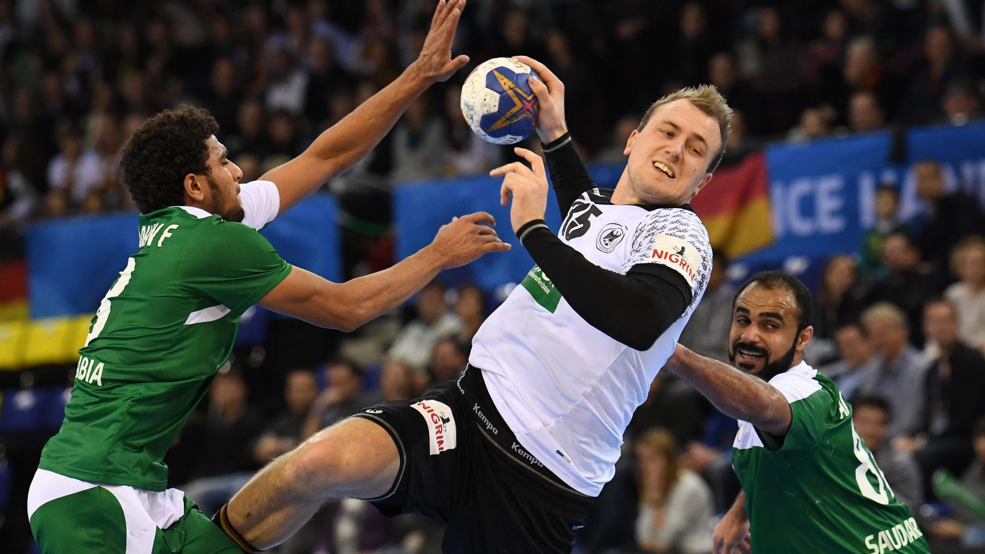 Ab durch die Mitte: Julius Kühn setzt sich gegen zwei Gegenspieler aus Saudi-Arabien (links Fahad Al Farhan, rechts Mohammed Al Zaer) bei der Handball-WM durch.