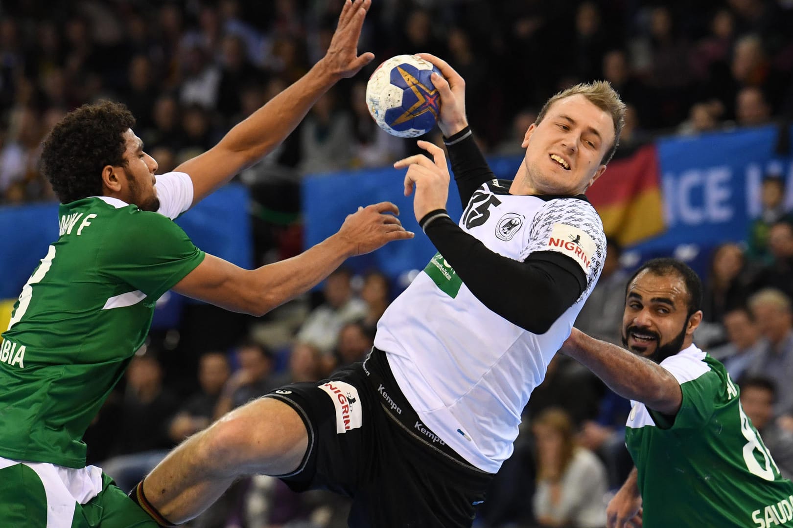 Ab durch die Mitte: Julius Kühn setzt sich gegen zwei Gegenspieler aus Saudi-Arabien (links Fahad Al Farhan, rechts Mohammed Al Zaer) bei der Handball-WM durch.