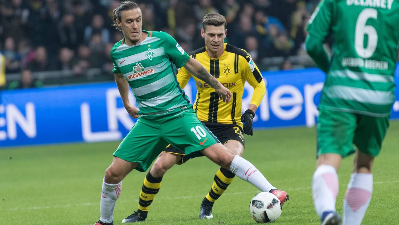 Bremens Max Kruse (li.) schirmt den Ball gegen BVB-Profi Lukasz Piszczek ab.