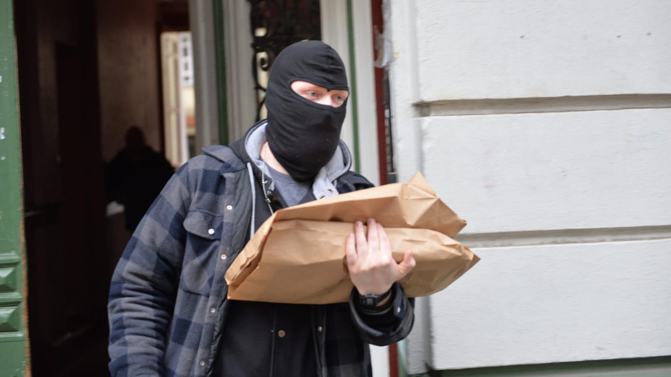 Razzia in Berlin: Ein Polizist trägt Beweismaterial aus einem Haus in der Wittstocker Straße in Berlin Moabit.