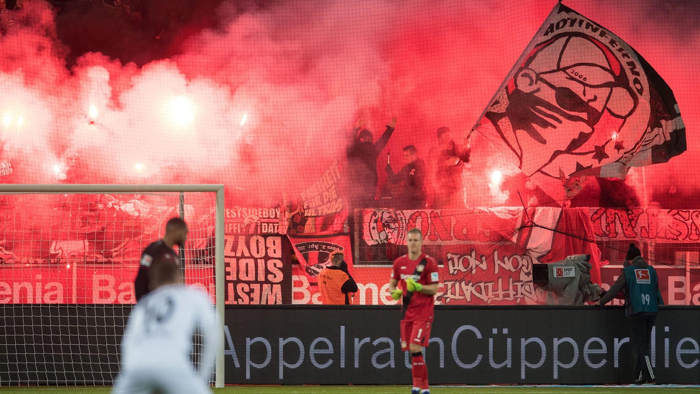 Leverkusener Fans brennen vor dem Spiel Bengalos ab und verletzen einen Kameramann.