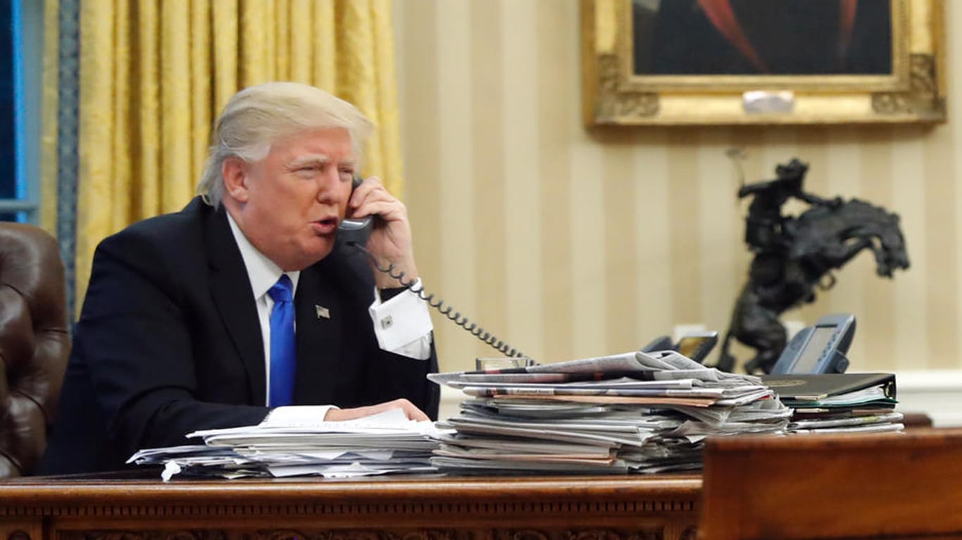 US Präsident Donald Trump telefoniert mit dem Premierminister von Australien, Malcolm Turnbull, im Oval Office vom Weißen Haus in Washington DC am 28.01.2017. In der Mitte der Nationale Sicherheitsberater Michael Flynn, center, und Chefstratege Steve Bannon rechts.