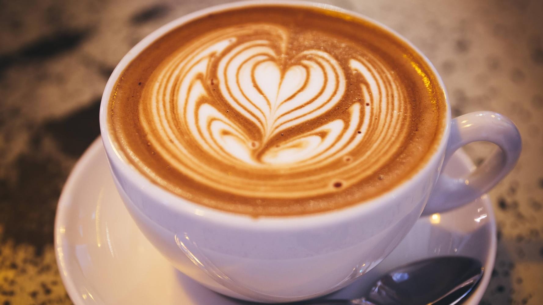 Kaffeegenuss: Eine Tasse Kaffee mit herzförmigem Milchschaum