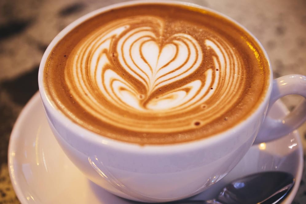 Kaffeegenuss: Eine Tasse Kaffee mit herzförmigem Milchschaum
