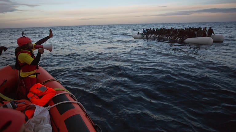 Afrikanische Flüchtlinge werden im Mittelmeer aus einem Schlauchboot gerettet.