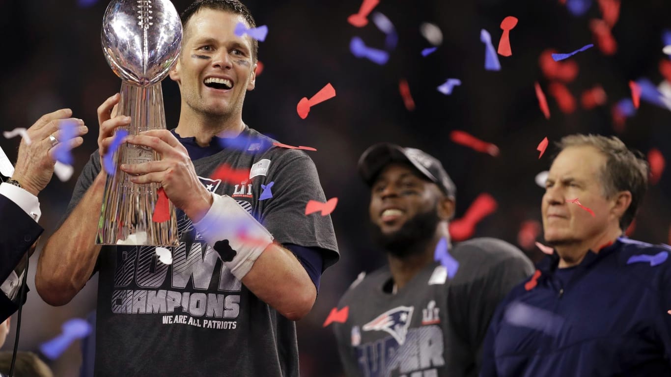 Patriots-Superstar Tom Brady hält stolz die Vince Lombardi Trophy.