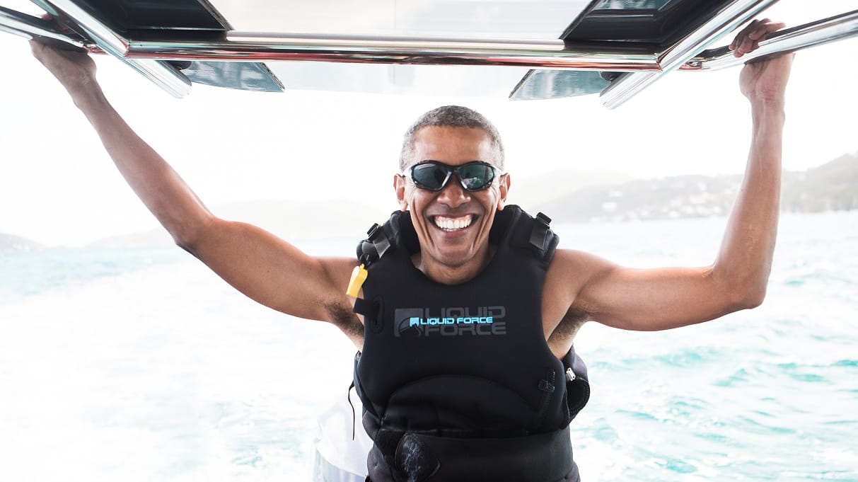 Ein strahlender Barack Obama versucht sich auf dem Surfbrett.