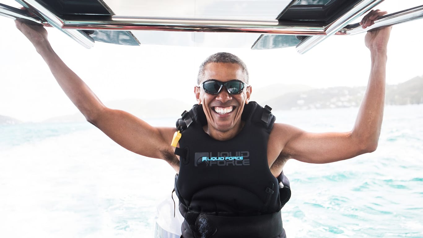 Ein strahlender Barack Obama versucht sich auf dem Surfbrett.