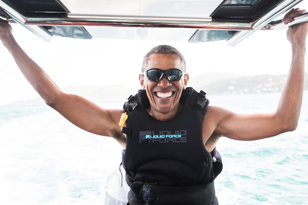 Ein strahlender Barack Obama versucht sich auf dem Surfbrett.