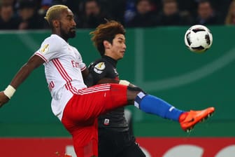Hamburgs Johan Djourou (li.) setzt sich gegen Yuya Osako durch.