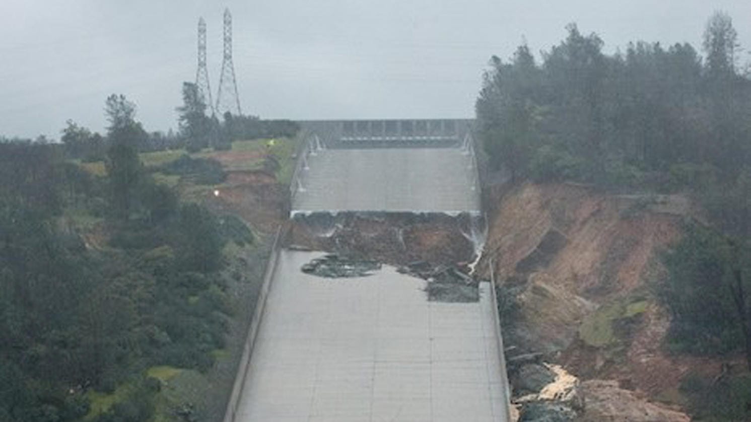 Der beschädigte Hauptüberlauf am Oroville-Stausee. Er soll mit großen Steinen stabilisiert werden, die per Hubschrauber abgesetzt werden. Der beschädigte Hauptüberlauf am Oroville-Stausee. Er soll mit großen Steinen stabilisiert werden, die per Hubschrauber abgesetzt werden.