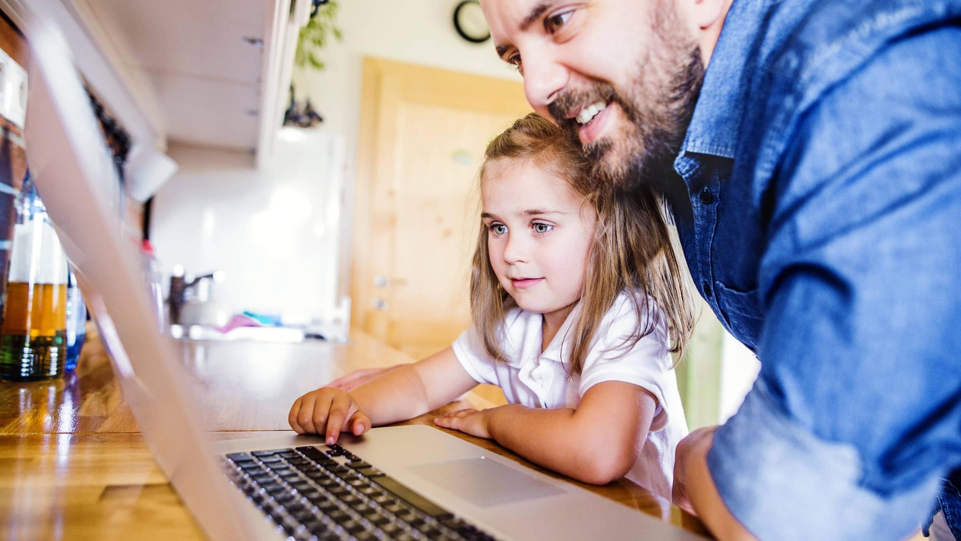 Tochter und Vater sitzen vor einem Laptop (Symbolfoto)