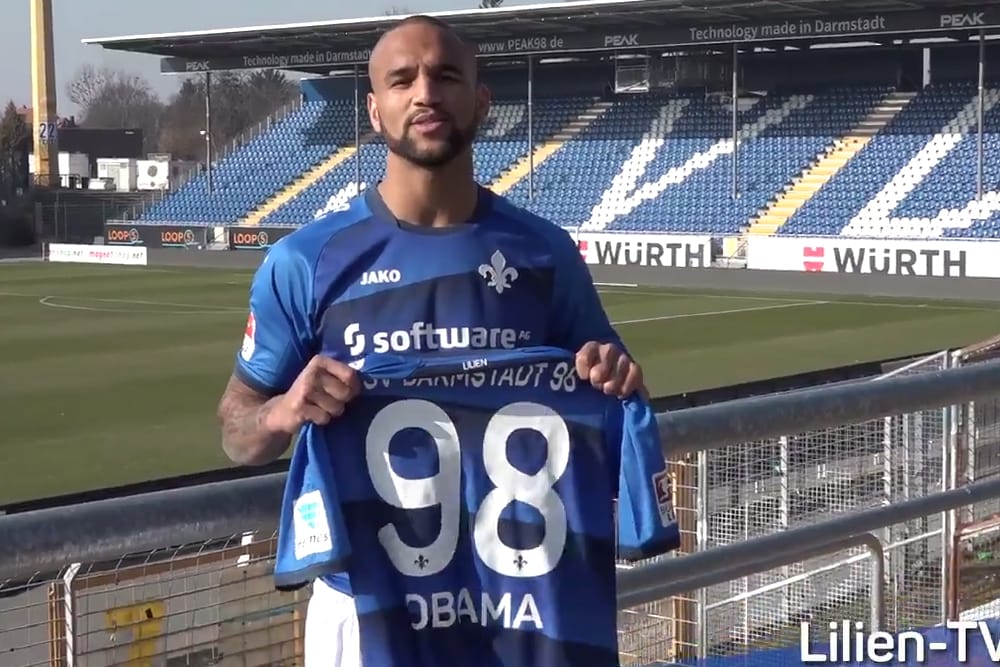 Darmstadt-Stürmer Boyd hält ein Obama-Trikot in die Kamera.