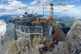 Die Materialseilbahn und der Baukran sind auf der Zugspitze vom Gipfelkreuz aus zu sehen.