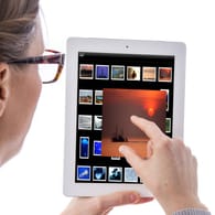 Eine Frau bearbeitet Bilder mit einem Tablet-Computer.