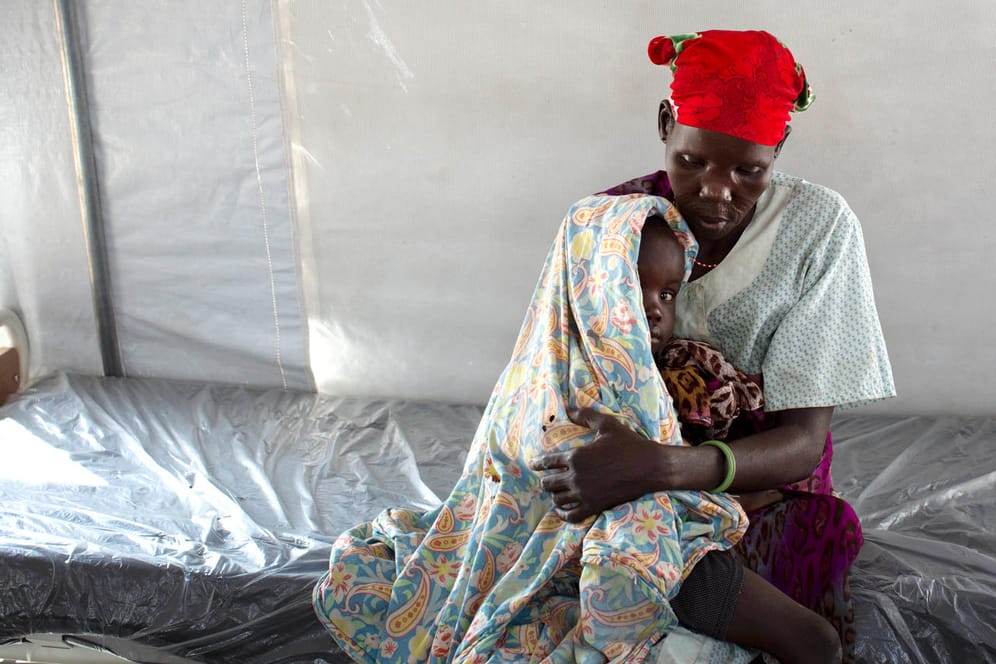 Hungersnot im Südsudan – Mutter hält ihr unterernährtes Kind in den Armen