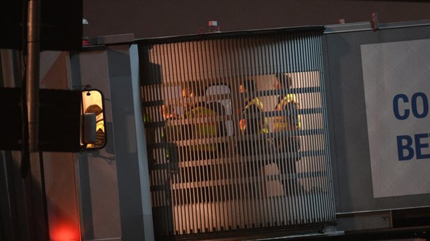 Am Frankfurter Flughafen begleiten Polizisten abgelehnte Asylbewerber in Flugzeug.