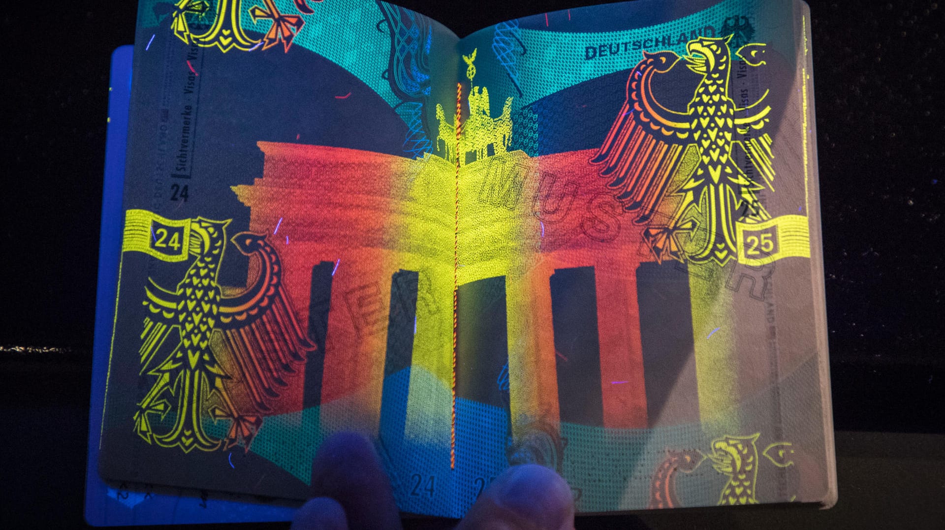 Unter Schwarzlicht leuchtet das Brandenburger Tor auf dem neuen Reisepass.