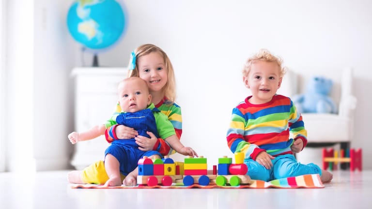 Drei Kinder spielen mit Bausteinen