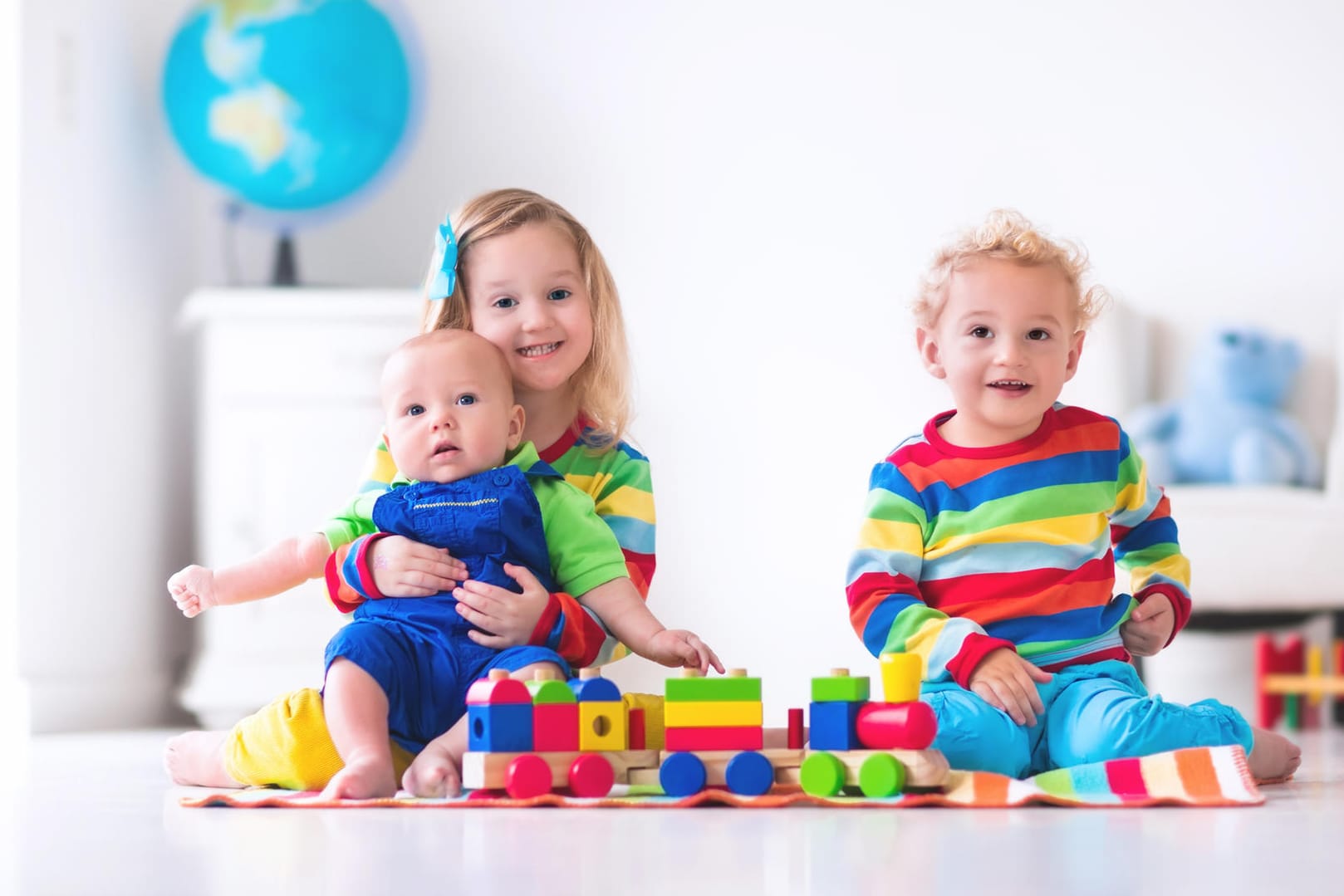 Drei Kinder spielen mit Bausteinen