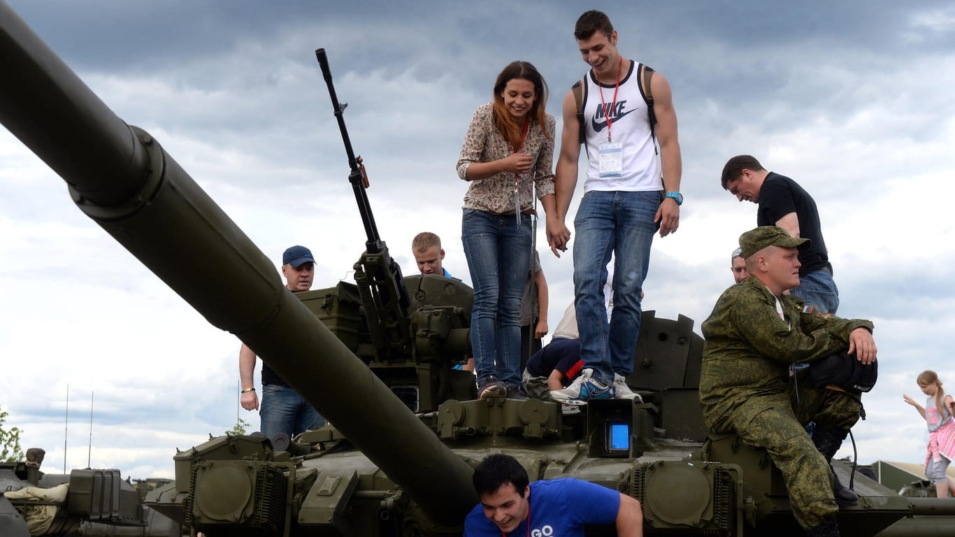 Besucher im Freizeitpark in Kubinka bei Moskau auf einem russischen T-72-Panzer.