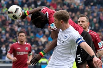 Hannovers Salif Sane (li.) und Bielefelds Fabian Klos kämpfen um den Ball.
