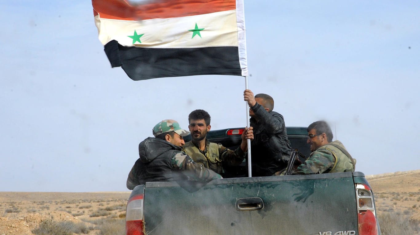 Syrische Soldaten patrouillieren in einem Truck in der Nähe von Homs.