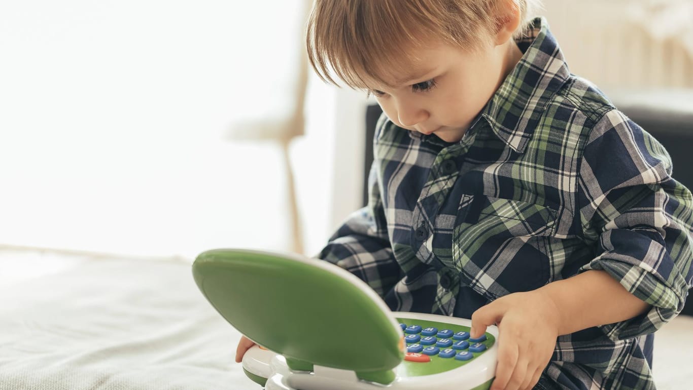 Ein kleiner Junge lernt mit einem smarten Spielzeug-Laptop