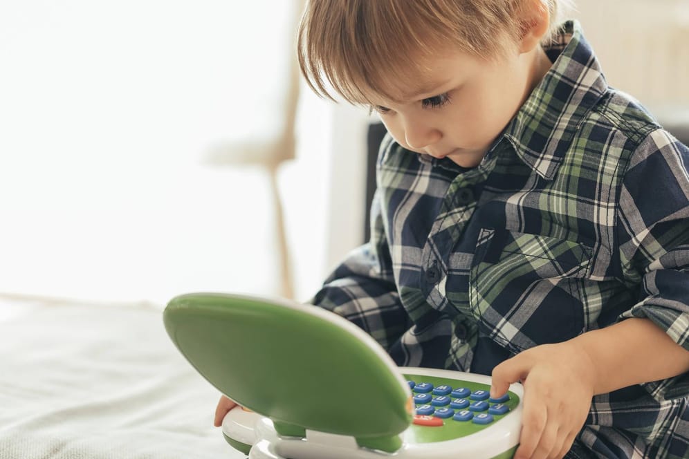 Ein kleiner Junge lernt mit einem smarten Spielzeug-Laptop