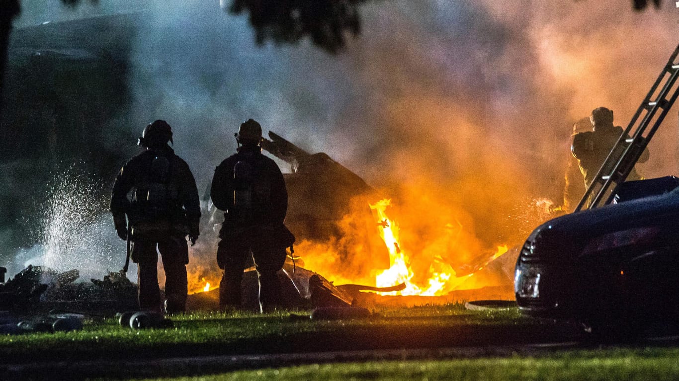 Feuerwehrmänner löschen in Riverside, Kalifornien, Flammen an der Absturzstelle des Kleinflugzeugs.