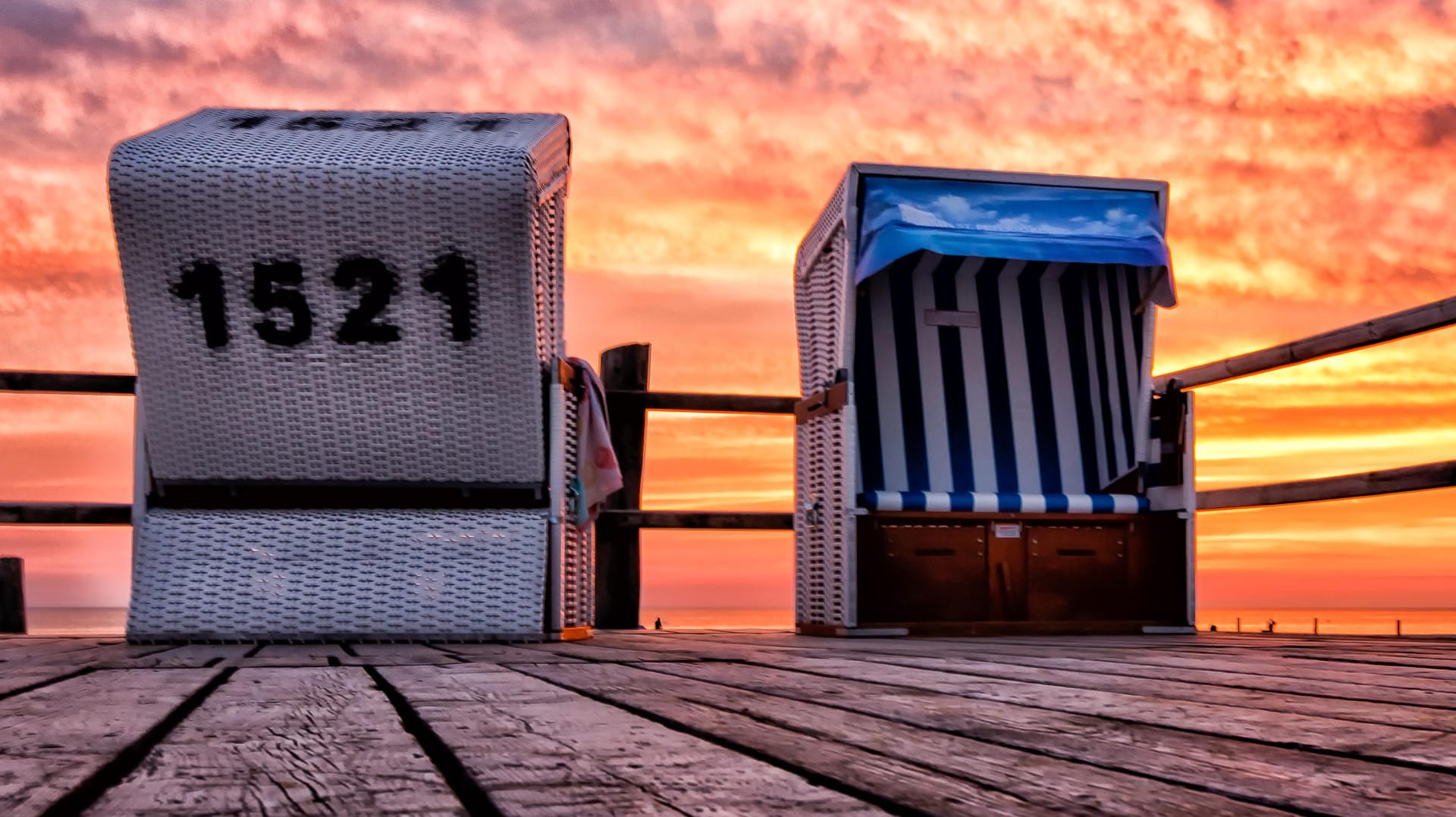 Strandkörbe vor einem Sonnenuntergang in St. Peter Ording