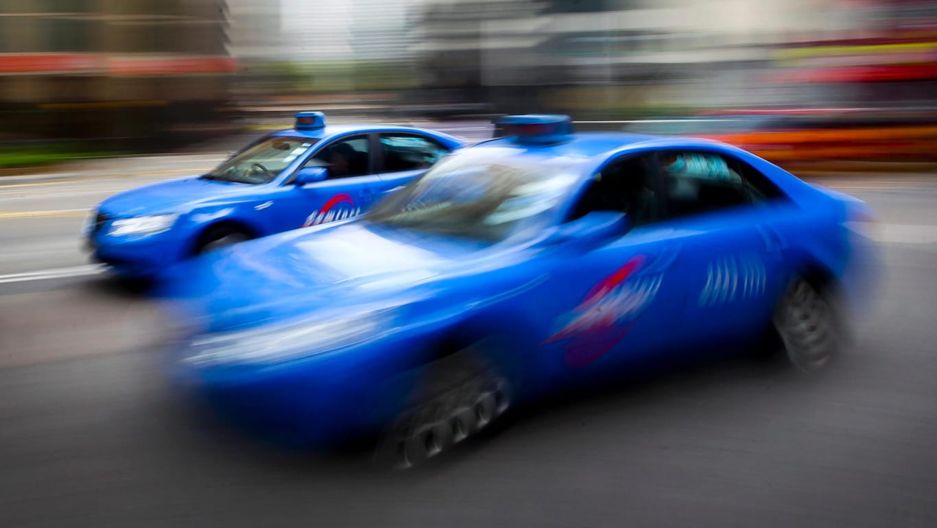 Zwei blaue Taxis fahren in Singapur