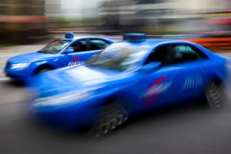 Zwei blaue Taxis fahren in Singapur
