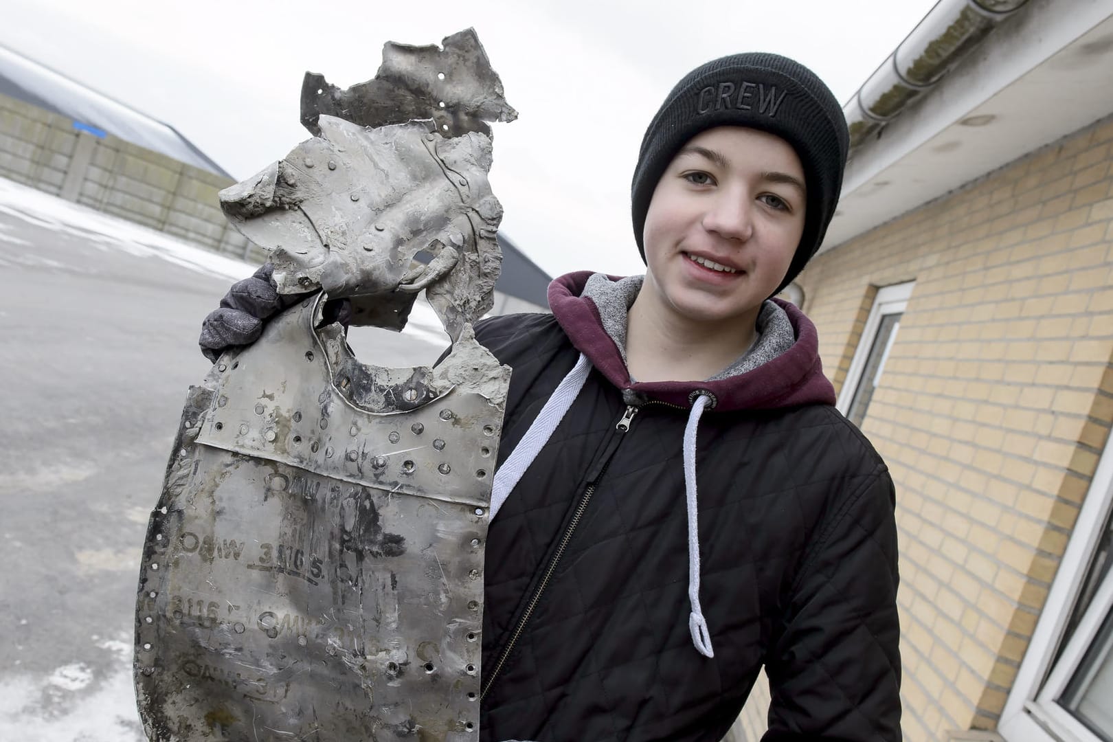 Der 14-jährige Däne Rom Kristiansen hält ein Wrackteil eines deutschen Jagdflugzeugs aus dem Zweiten Weltkrieg in den Händen. Es handelt sich laut Polizei um eine ME 109 Messerschmitt.