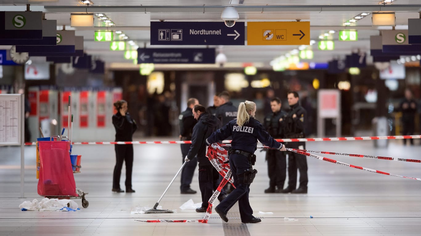 Polizisten entfernen am Freitag nach Mitternacht im Hauptbahnhof von Düsseldorf (Nordrhein-Westfalen) die Absperrbänder. Am Morgen nach dem Amoklauf läuft der Pendlerverkehr wieder, als wäre nichts gewesen.