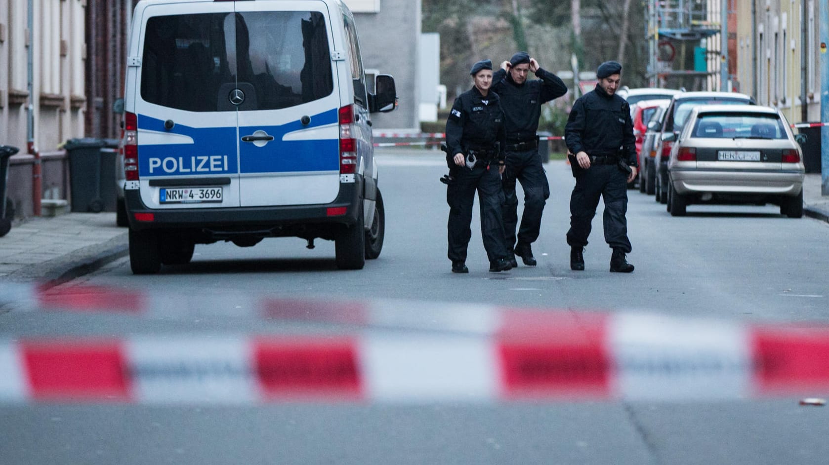 Polizeibeamte gehen in Herne über die gesperrte Sedanstraße.