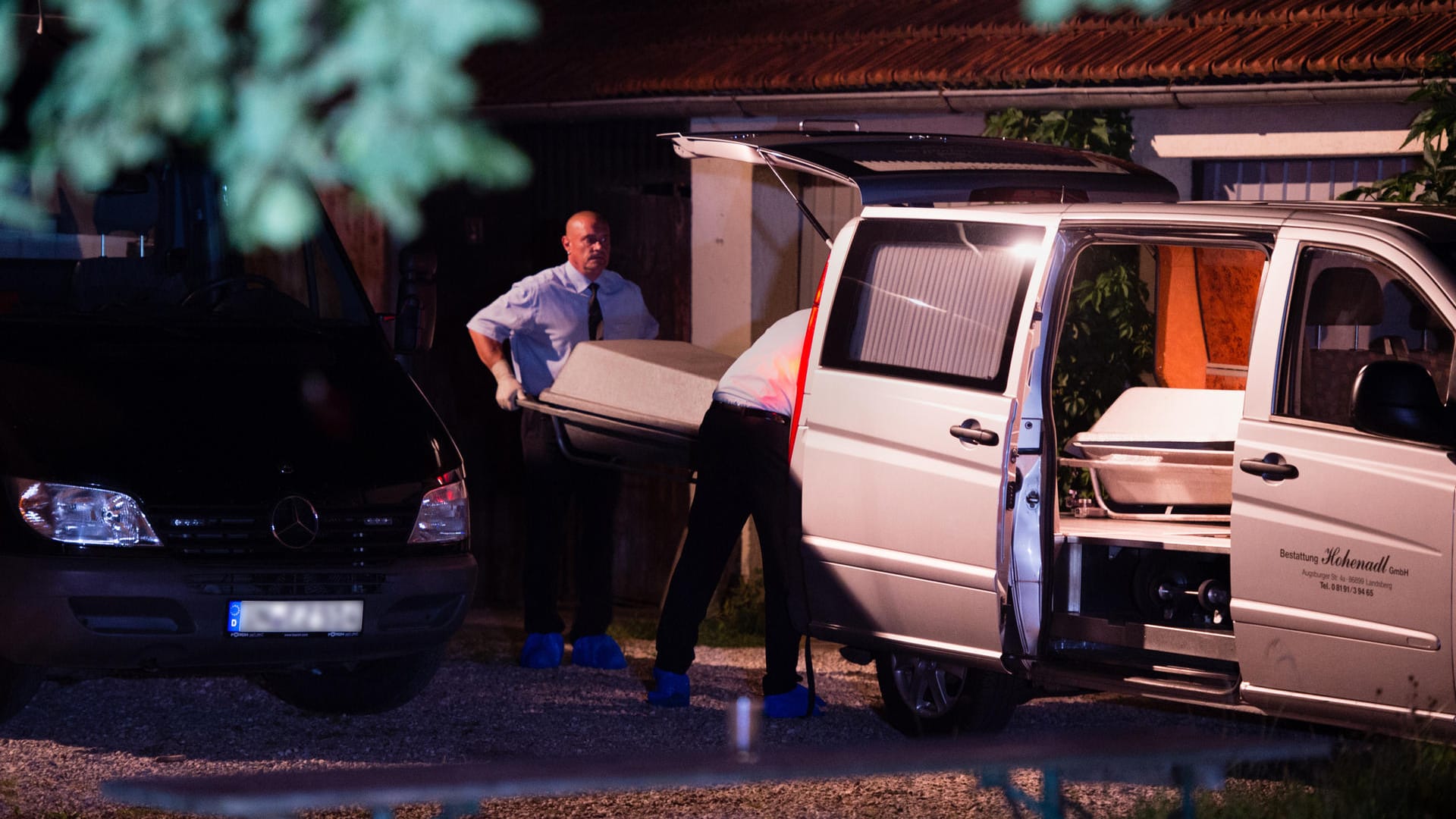 Bestatter tragen am 17.08.2016 nach dem Doppelmord einen Sarg zu einem Leichenwagen.
