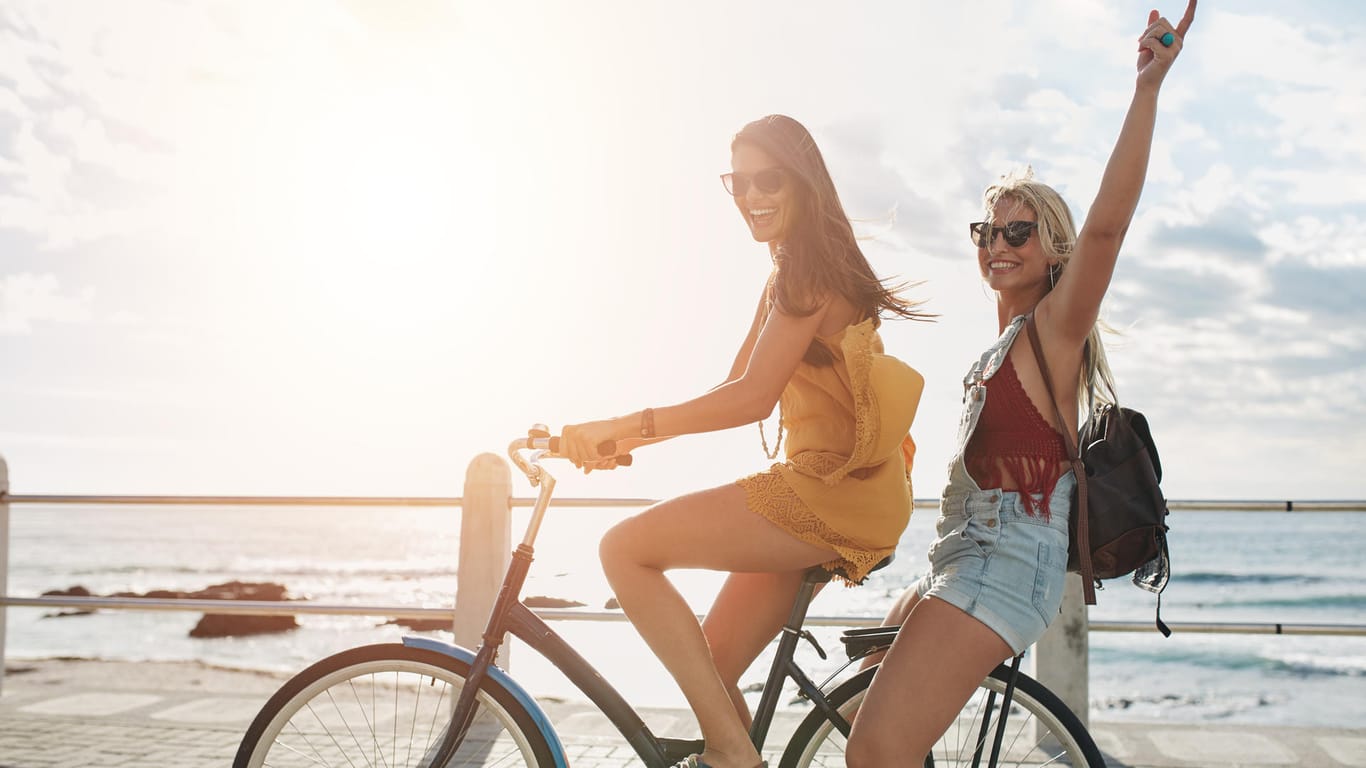 Zwei junge Frauen fahren mit dem Fahrrad