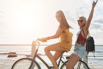 Zwei junge Frauen fahren mit dem Fahrrad