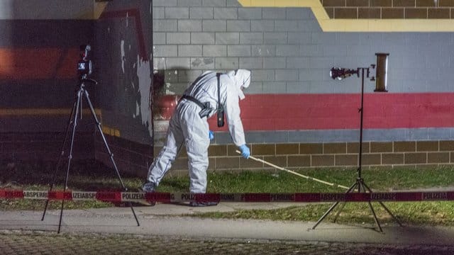 Ein Polizist untersucht in Weimar vor einem Haus Spuren auf einen Rasenstück. Ein Polizist untersucht in Weimar vor einem Haus Spuren auf einen Rasenstück.