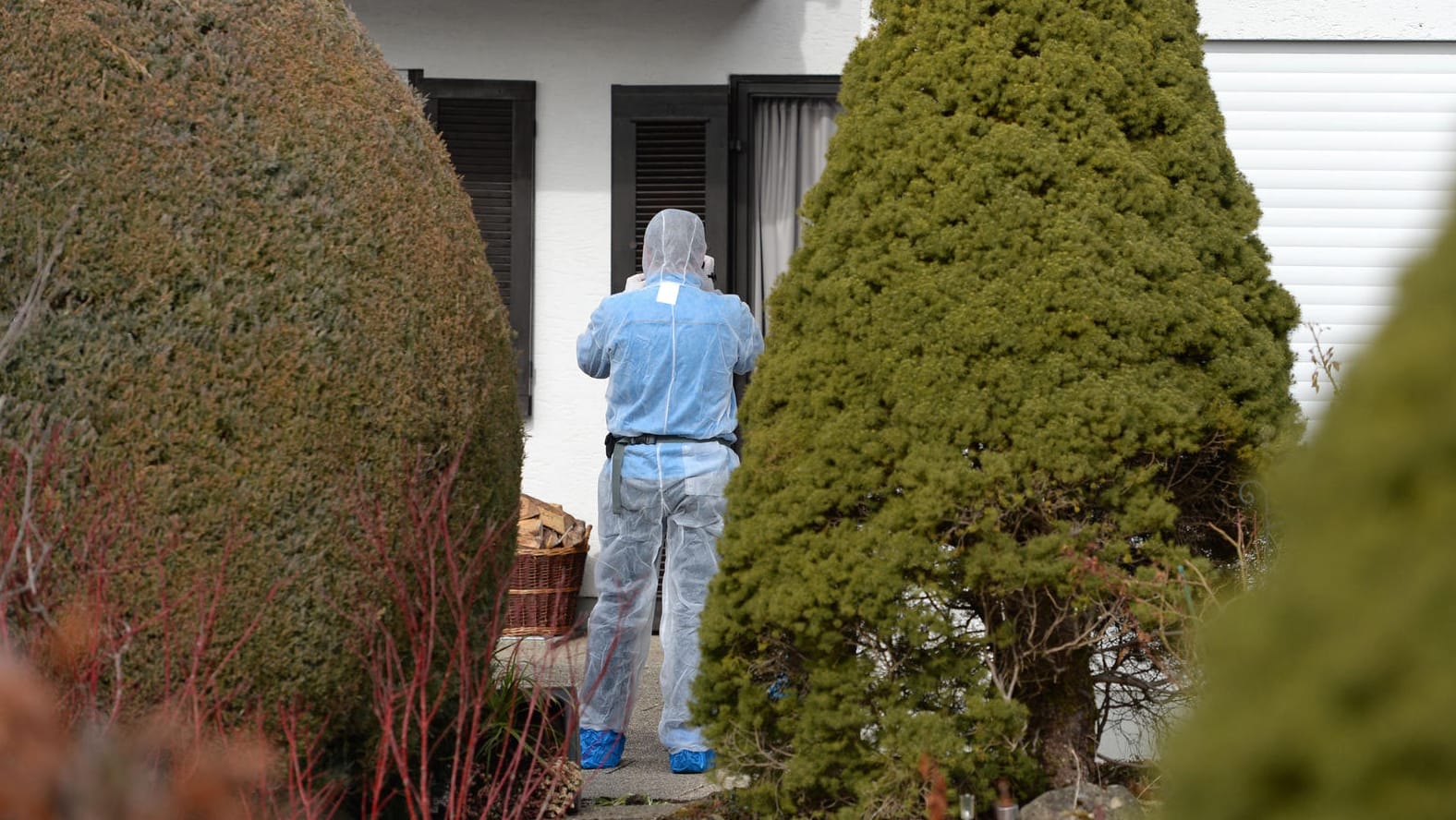 Ein Mitarbeiter der Spurensicherung steht vor einem Haus in Höfen bei Königsdorf in Bayern. Ein Mitarbeiter der Spurensicherung steht vor einem Haus in Höfen bei Königsdorf in Bayern.