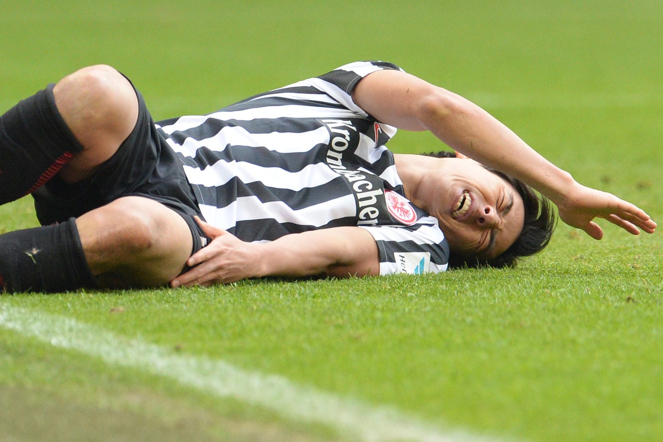 Eintrachts Makoto Hasebe liegt nach dem Pfostenpraller auf dem Rasen.