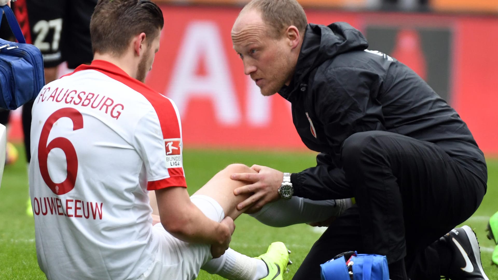 Augsburgs Jeffrey Gouweleeuw wird im Spiel gegen den FC Freiburg am Knie behandelt. Augsburgs Jeffrey Gouweleeuw wird im Spiel gegen den FC Freiburg am Knie behandelt.